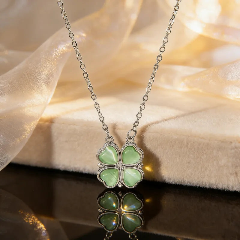 Necklace with a green four-leaf clover pendant on a soft fabric background