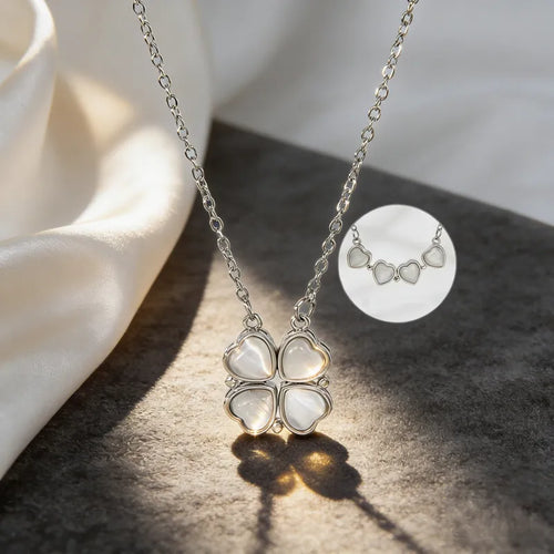 Silver necklace with a four-leaf clover pendant on a textured surface