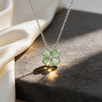 Necklace with a green four-leaf clover pendant on a textured surface