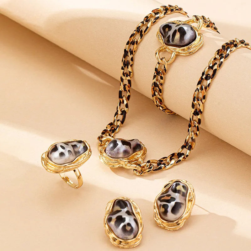 Jewelry set with leopard print and gold accents on a beige background