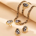 Jewelry set with leopard print and gold accents on a beige background
