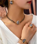 Close-up of a person wearing gold jewelry including a necklace, ring, and bracelet.