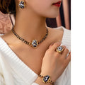 Close-up of a person wearing gold jewelry including a necklace, ring, and bracelet.