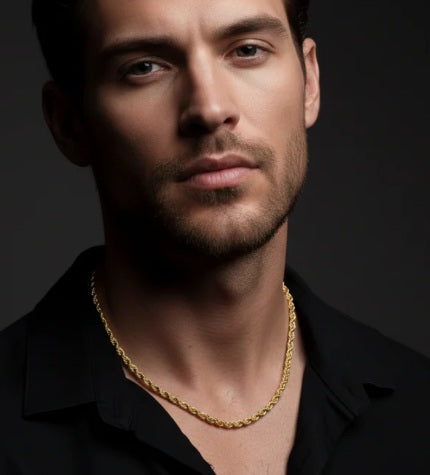 Man wearing a gold chain necklace against a dark background