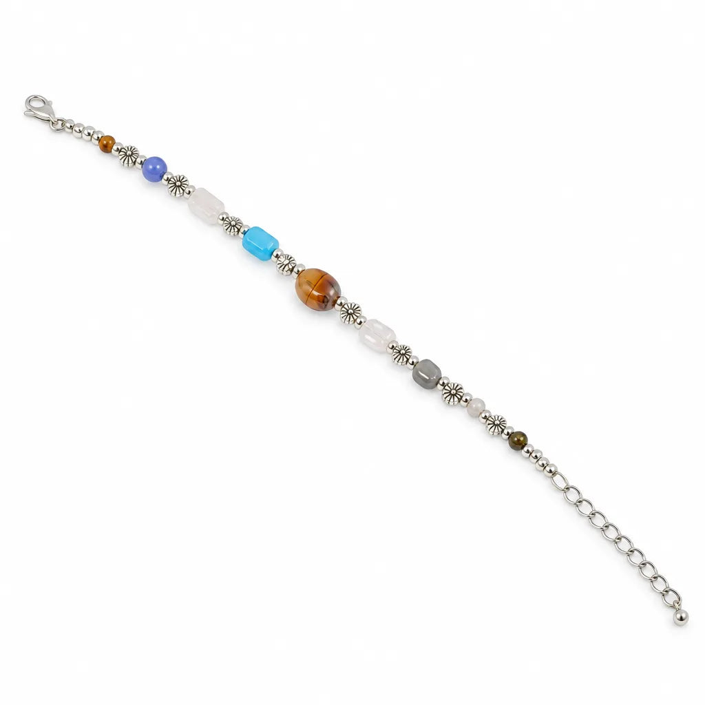 A silver chain bracelet with a series of colorful beads, including a large round brown tiger's eye bead, a light blue cube bead, a medium blue bead, a white oval bead, a gray round bead, and small metallic silver beads, displayed on a clean white background.