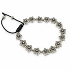 A silver-toned beaded bracelet featuring a series of small flower-shaped beads connected by small round beads, with a black adjustable cord closure on a white background.