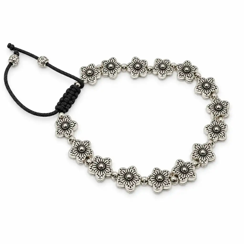 A silver-toned beaded bracelet featuring a series of small flower-shaped beads connected by small round beads, with a black adjustable cord closure on a white background.