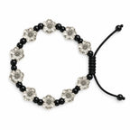 A beaded stretch bracelet featuring alternating black round beads and silver-toned flower-shaped beads, with a black adjustable cord closure, shown on a plain white background.