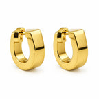 A pair of polished yellow gold huggie hoop earrings on a clean white background.