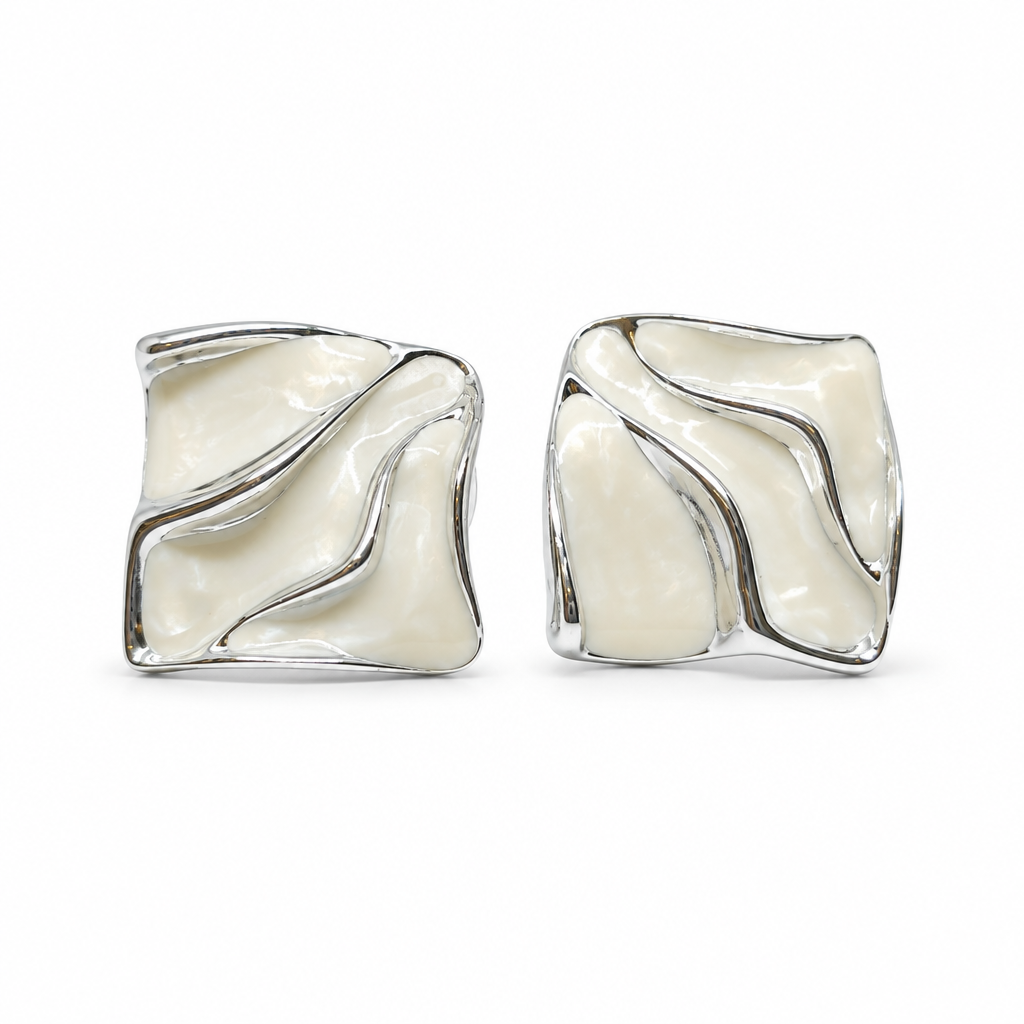 A pair of square stud earrings with a wavy, fluid design, featuring a glossy cream-colored inlay set in a polished silver-tone metal, shown against a plain white background.