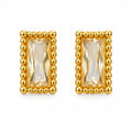 A pair of gold rectangular stud earrings featuring a faceted clear crystal center, surrounded by a raised beaded gold border, set against a plain white background.